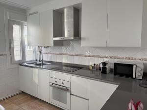 een keuken met witte kasten en een magnetron bij A CALZADA in Cambados