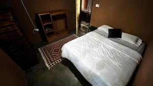 a bedroom with a white bed and a fireplace at Zoko cottage in Maun