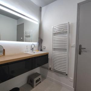 een badkamer met een wastafel en een spiegel bij Le Bis in Guer