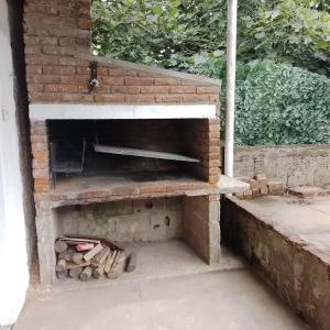 an outdoor brick pizza oven with logs in it at La Olimareña in Treinta y Tres +4 photos