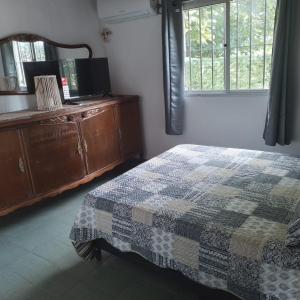 a bedroom with a bed and a dresser and a window at La Olimareña in Treinta y Tres