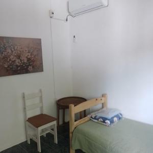 a bedroom with a bed and a table and a chair at La Olimareña in Treinta y Tres