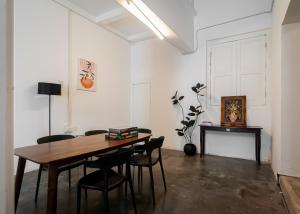 een eetkamer met een houten tafel en stoelen bij The Terraces by Aayu - 2 mins walk to Chulia Street in George Town