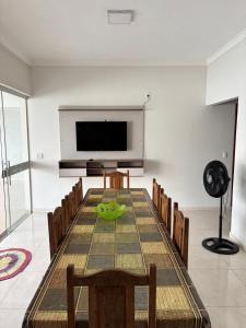 een kamer met een tafel en stoelen en een flatscreen-tv bij Casa Toledo in Olímpia