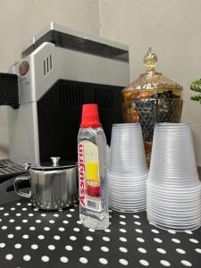 a bottle of sauce sitting on a table with plates at #108 Suíte Acolhedora com vaga Centro de Itatiba in Itatiba +3 photos