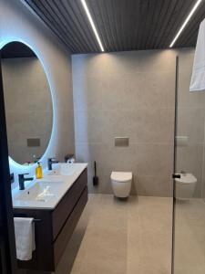 une salle de bains avec lavabo, toilettes et miroir dans l'établissement LyNora Lodge,  33 autres photos