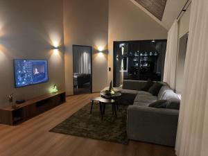 un salon avec un canapé et une télévision dans l'établissement LyNora Lodge, 
