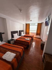 ein Hotelzimmer mit 4 Betten in einem Zimmer in der Unterkunft Hostal Mónaco in Machu Picchu