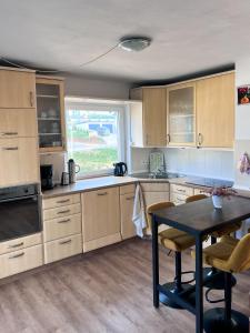 a kitchen with wooden cabinets and a table in it at Ferienwohnung Wolfsgarten in Rauschenberg