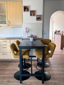 a kitchen with a blue table and some chairs at Ferienwohnung Wolfsgarten in Rauschenberg