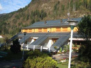 een groot gebouw met een zonnedak op een berg bij Casa Per Ferie Arta Terme in Arta Terme