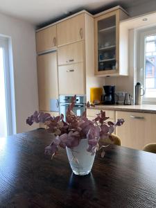 a vase filled with purple flowers sitting on a table at Ferienwohnung Wolfsgarten in Rauschenberg