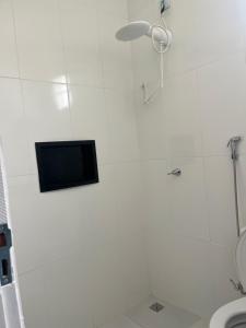 a bathroom with a shower with a tv on the wall at Suíte privativa in Boa Vista