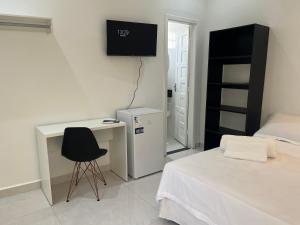 a bedroom with a bed and a desk and a chair at Suíte privativa in Boa Vista