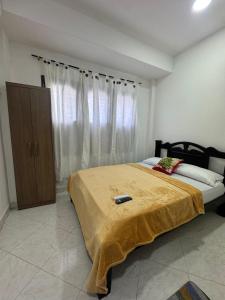 a bedroom with a bed with a yellow blanket on it at Hotel Casa Colonial Moñitos in Moñitos +10 photos