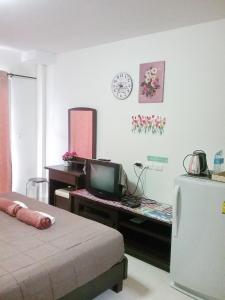 a room with a desk with a computer and a refrigerator at We Love Kata in Kata Beach