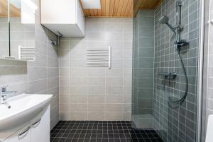 un bagno con doccia e lavandino di Cozy apartment for three by the ski trails a Sotkamo