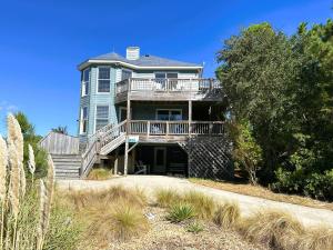 a large blue house with a deck and stairs at D112-Happy Go Ducky in Duck