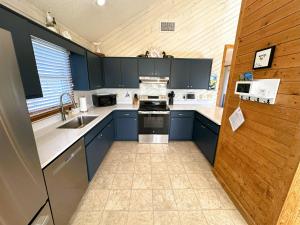 a kitchen with blue cabinets and a stove top oven at D112-Happy Go Ducky in Duck