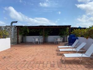een patio met witte stoelen en een tafel en stoelen bij Virrey Luxury Aparments in Ciudad Amurallada in Cartagena