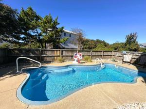 a small swimming pool with a chair in a yard at D112-Happy Go Ducky in Duck