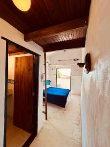 Kleines Zimmer mit einem Bett und einer Tür in der Unterkunft Janaína Picinguaba in Ubatuba