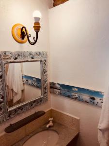 ein Badezimmer mit Spiegel und Waschbecken in der Unterkunft Janaína Picinguaba in Ubatuba + 17 Fotos