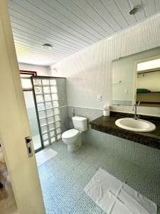 a bathroom with a toilet and a sink and a mirror at Pousada Maliale in Ilha de Boipeba