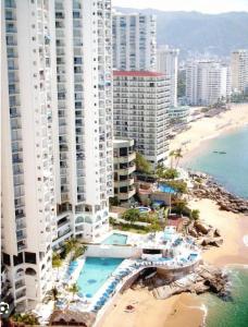 an aerial view of a beach with tall buildings at Torres Gemelas Costera MA con Playa Privada in Acapulco
