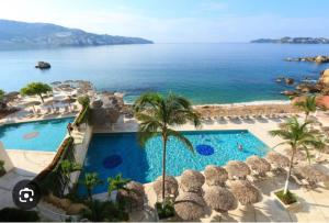 an aerial view of a resort with a swimming pool and the ocean at Torres Gemelas Costera MA con Playa Privada in Acapulco