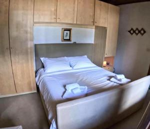 een groot wit bed met twee handdoeken erop bij Rium Dolomiti - Casa con Vista in Pieve di Cadore