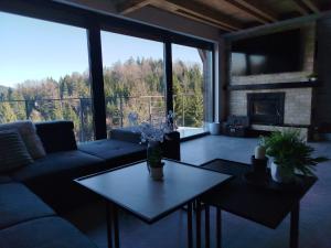 a living room with a couch and a table and a fireplace at Top Hill Vista in Sekulić 