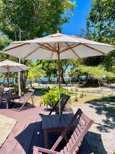 a picnic table with an umbrella on a patio at Pousada Maliale in Ilha de Boipeba +15 photos