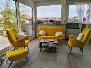 een woonkamer met gele stoelen en een bank bij Rooms Il Punto in Peschiera del Garda