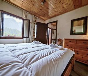 een slaapkamer met drie bedden, een raam en een commode bij Rium Dolomiti - Casa con Vista in Pieve di Cadore