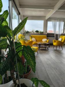 een woonkamer met een gele bank en een plant bij Rooms Il Punto in Peschiera del Garda