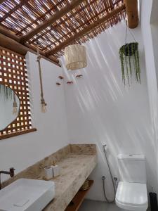 a white bathroom with a toilet and a sink at Casa Miava - Studio 1 in Marau