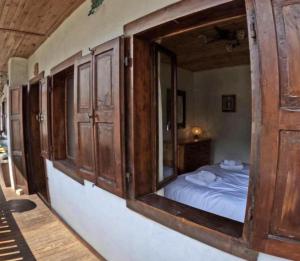 een slaapkamer met een bed en een groot houten raam bij Rium Dolomiti - Casa con Vista in Pieve di Cadore +33 foto's