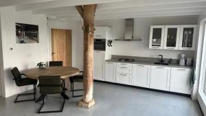 a kitchen with a table and chairs in a room at Benbijdokkum in Driesum