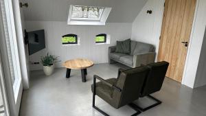 een woonkamer met een stoel en een tafel bij Benbijdokkum in Driesum