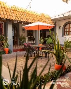 een patio met een tafel en een parasol bij Hotel Los Balcones Leon in León