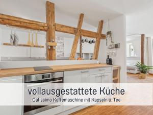 een keuken met witte kasten en houten balken bij Albert & Viktoria Loft mit Parkplätzen in Coburg