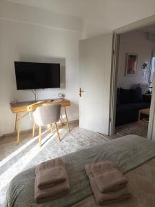 una camera da letto con un letto, una scrivania e una televisione di Dn'A home by the lake a Anatolí
