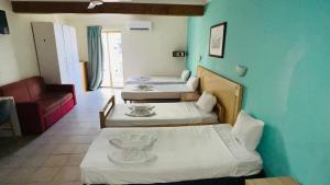 una stanza con tre letti e un divano e una stanza con di Quad Studio 2936 a San Pawl il-Baħar