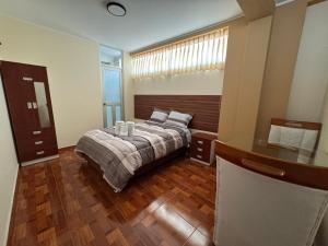 een slaapkamer met een bed en een houten vloer bij Gran Hotel Real in Huancayo