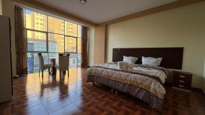 een slaapkamer met een bed, een bureau en een raam bij Gran Hotel Real in Huancayo