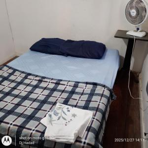 een bed met een blauwe en witte deken en een ventilator bij Santa Alexandrina in Rio de Janeiro