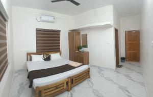 ein Schlafzimmer mit einem Bett in einem Zimmer mit Marmorböden in der Unterkunft Sandora Home Stay in Varkala