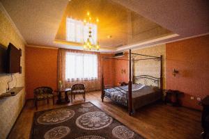 a bedroom with a canopy bed and a table at Park EmpAir Hotel in Pavlodar