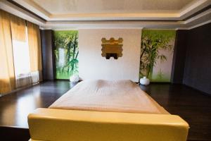 a large bed in a room with paintings on the wall at Park EmpAir Hotel in Pavlodar